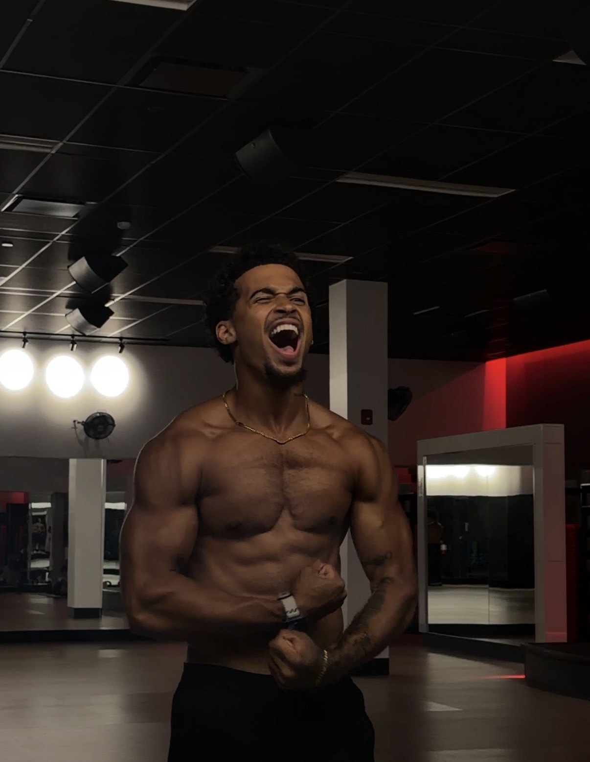 Coach flexing in the gym after a 16-week transformation